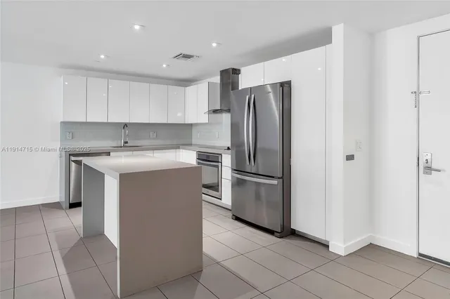a kitchen with a refrigerator sink and cabinets