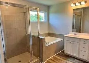 a bathroom with a granite countertop sink a mirror and shower