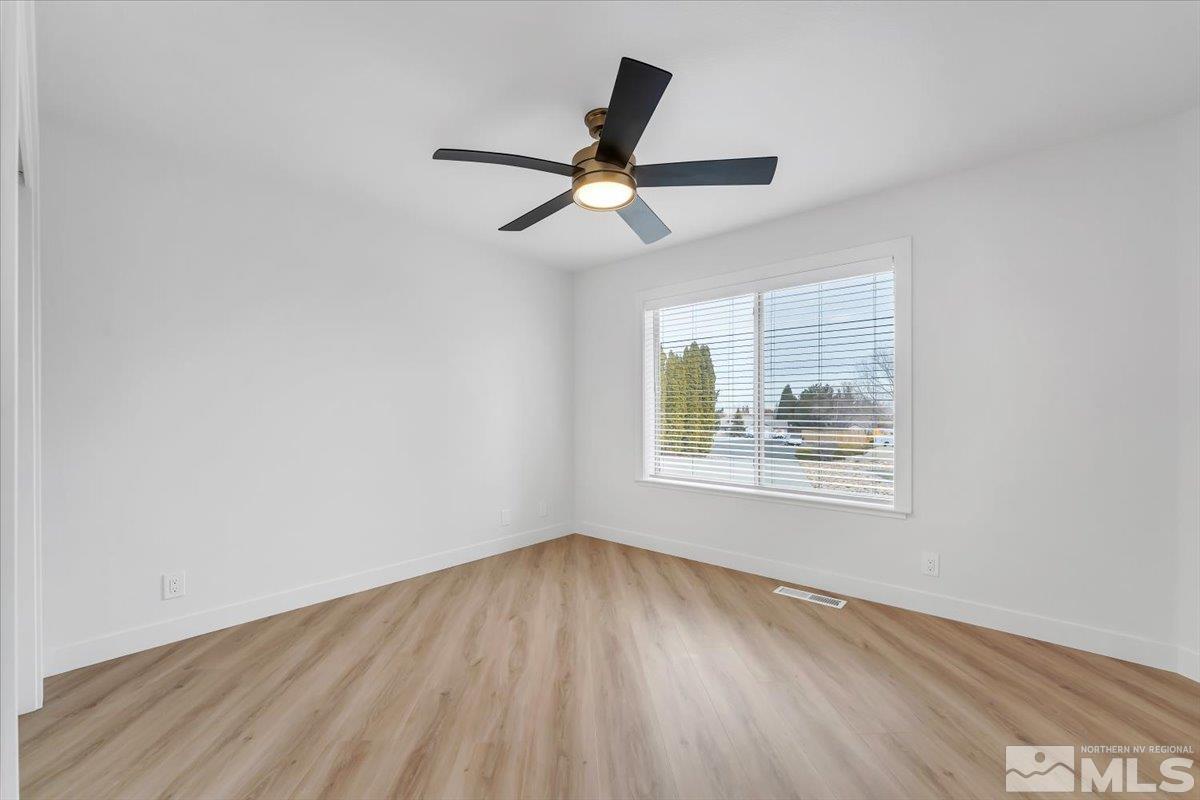 45 Water Lily Court Reno, NV 89511 - Photo 12 of 25 an empty room with wooden floor ceiling fan and windows