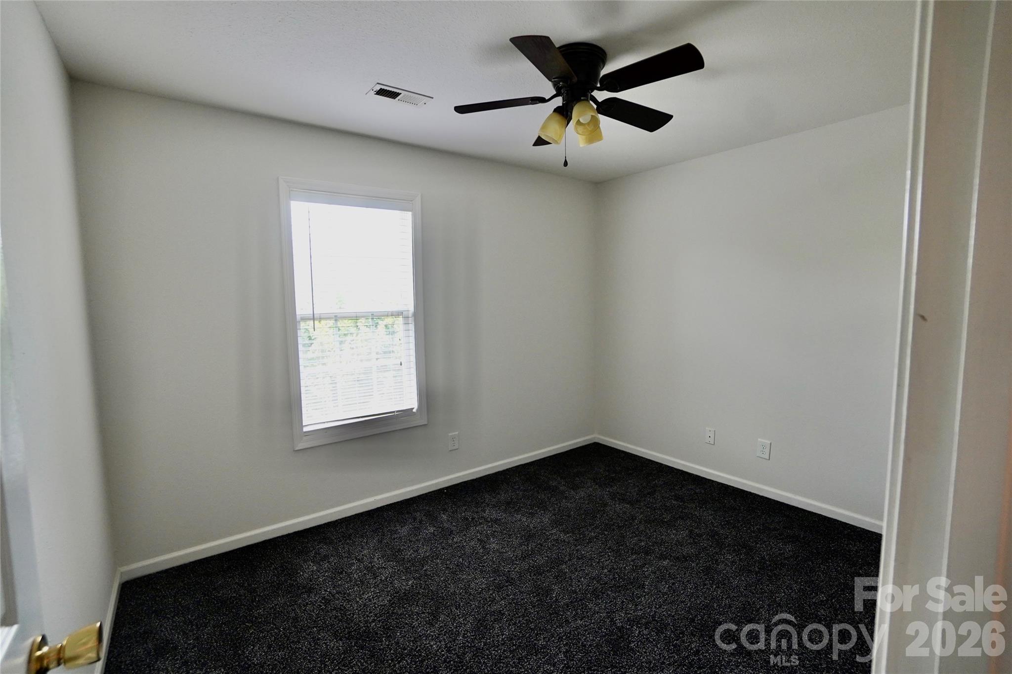4010 Town Center Road Harrisburg, NC 28075 - Photo 10 of 17 an empty room with a window and a fan