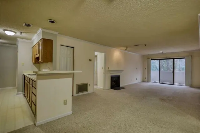 a view of an empty room with a fireplace and a window