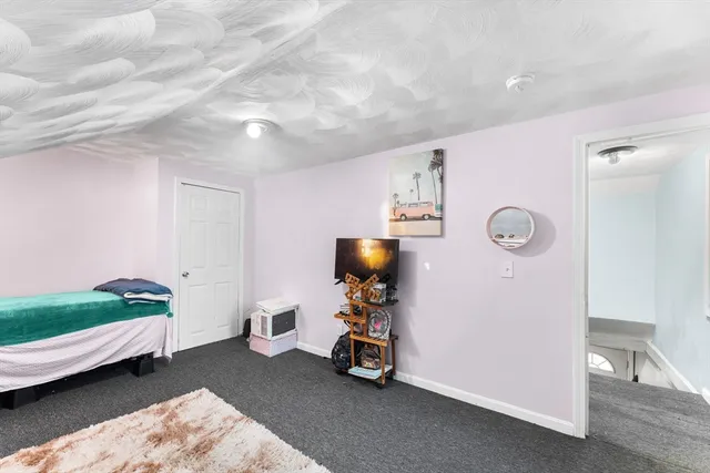 a view of a bedroom with baby crib and lounge chair