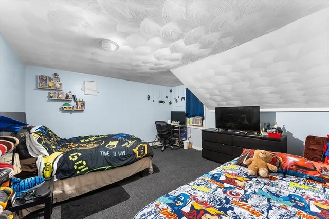 a bedroom with furniture and a flat screen tv