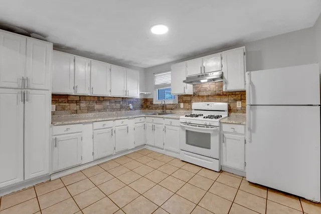 a kitchen with white cabinets and white appliances