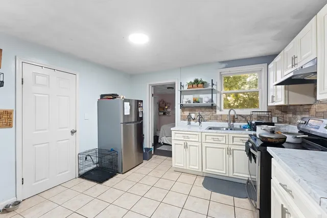 a kitchen with a sink a refrigerator and cabinets
