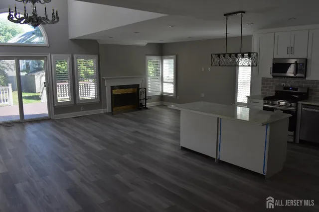 a kitchen with granite countertop wooden floors and wide window
