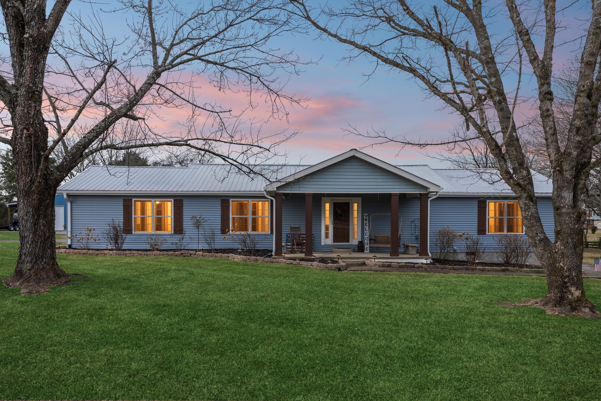 a front view of a house with a yard and trees