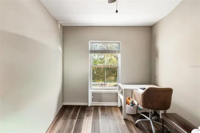 a view of a workspace with furniture and a window