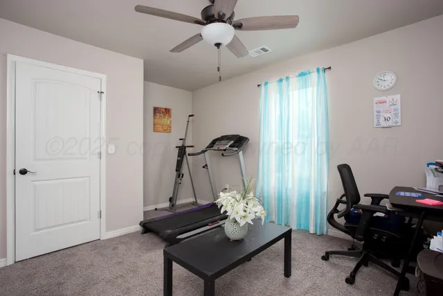 a view of a workspace with furniture and a window