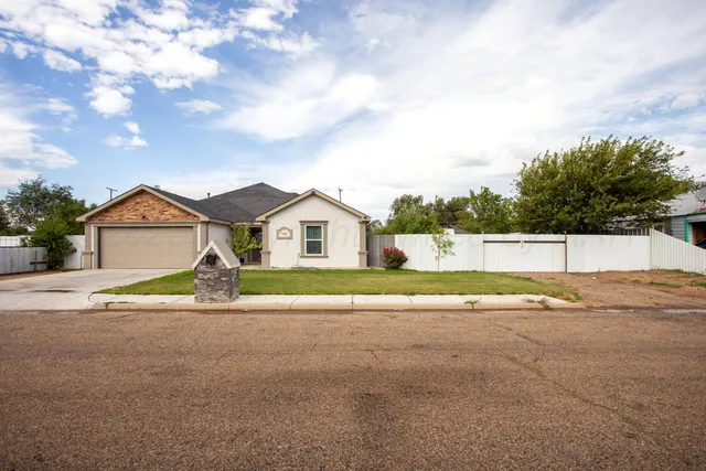 a view of white house with a yard and large trees