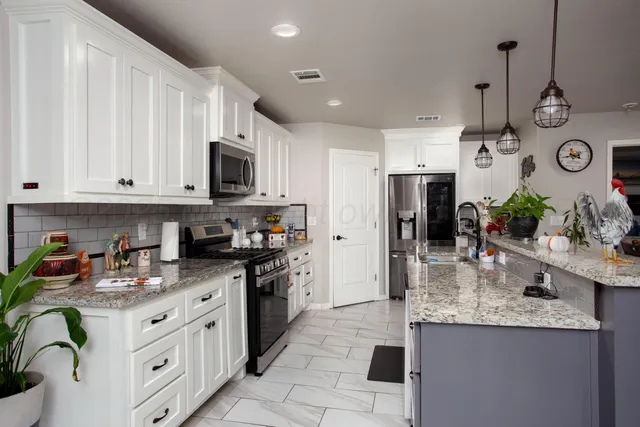 a kitchen with stainless steel appliances granite countertop a sink and cabinets