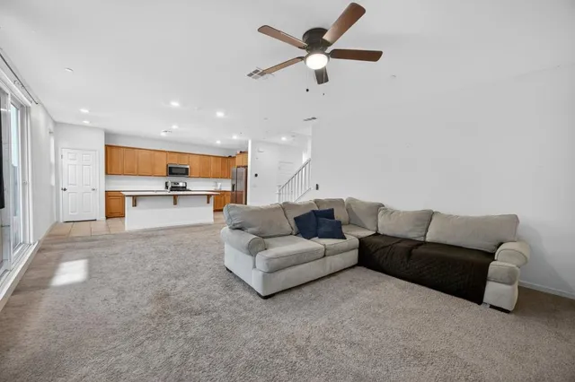 a living room with furniture and a view of kitchen