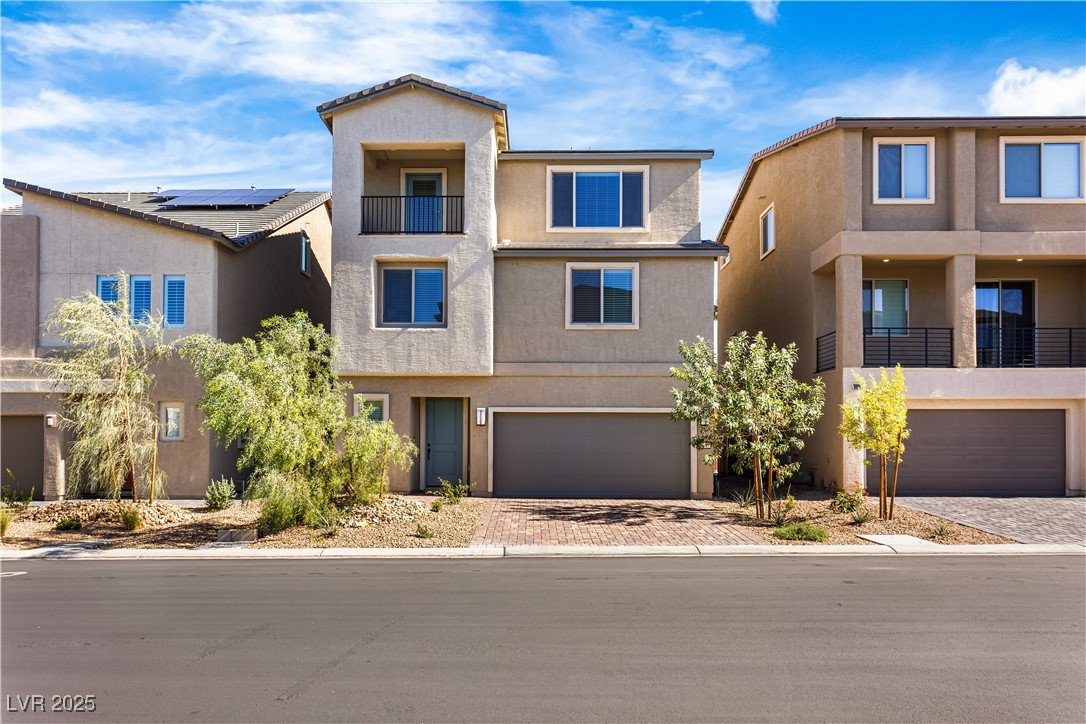 5646 Spring Trellis Street Las Vegas, NV 89113 - Photo 1 of 25 View of front of home featuring stucco siding, decorative driveway, an attached garage, and a balcony