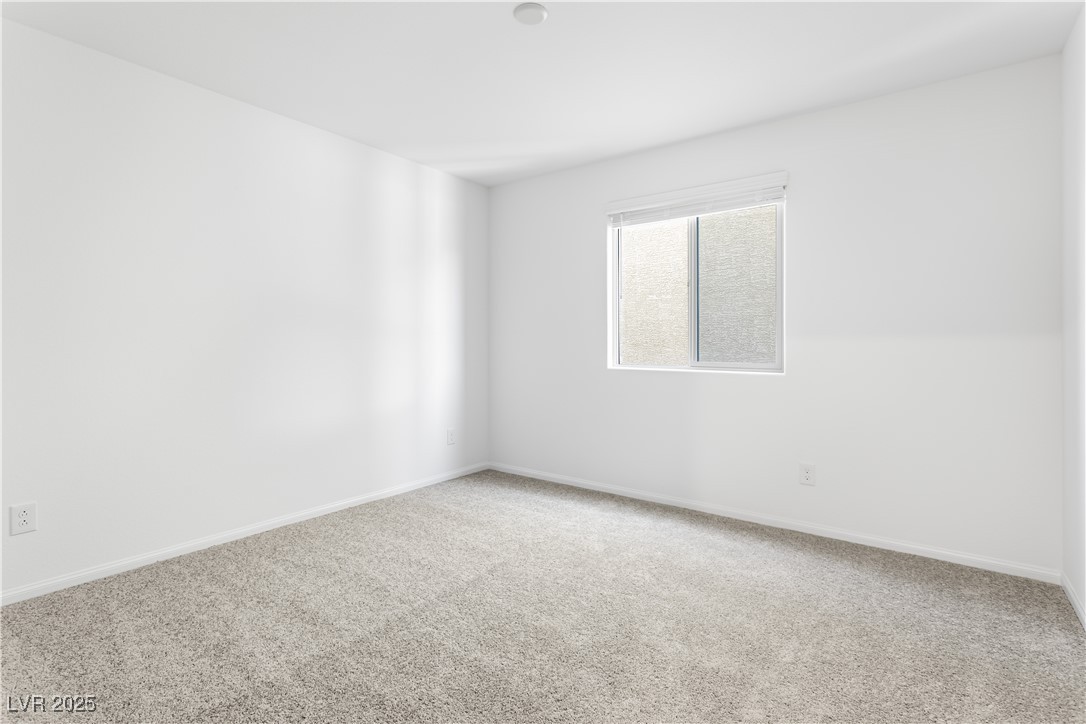 5646 Spring Trellis Street Las Vegas, NV 89113 - Photo 11 of 25 Carpeted spare room featuring baseboards