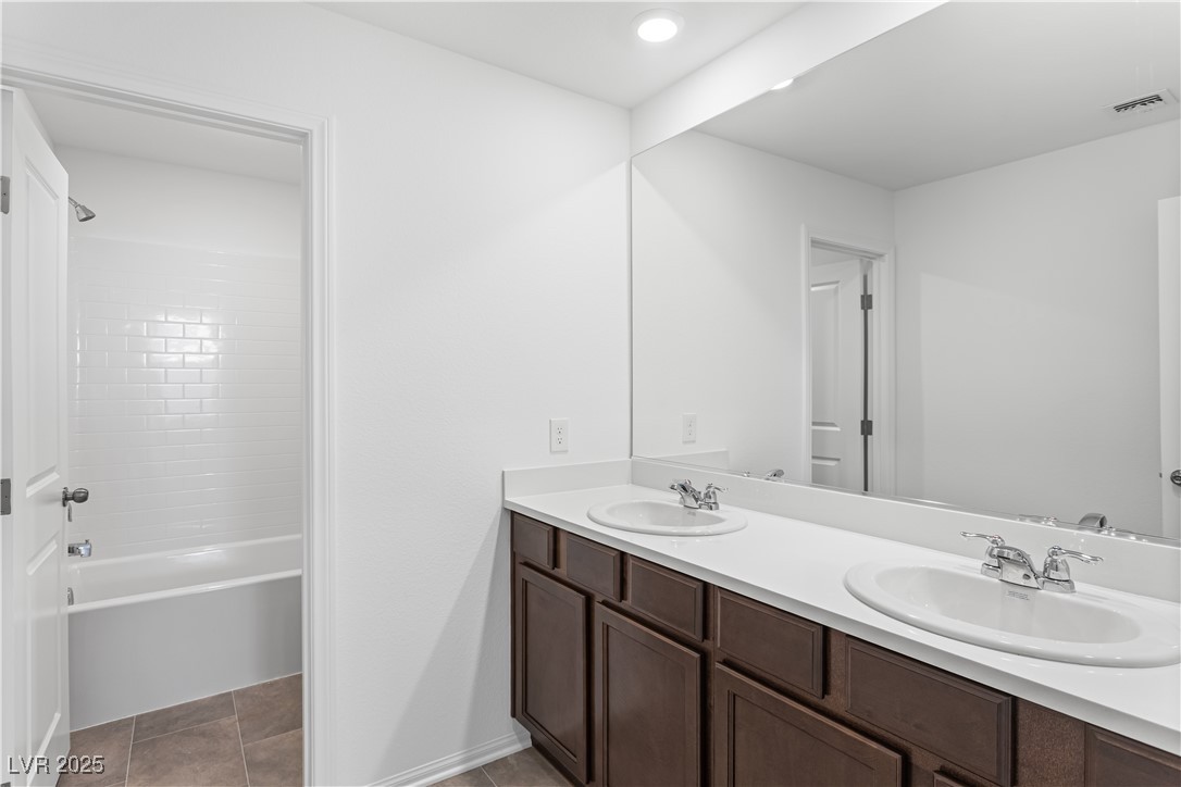5646 Spring Trellis Street Las Vegas, NV 89113 - Photo 14 of 25 Bathroom featuring double vanity, light tile patterned flooring, shower / bathtub combination, and recessed lighting