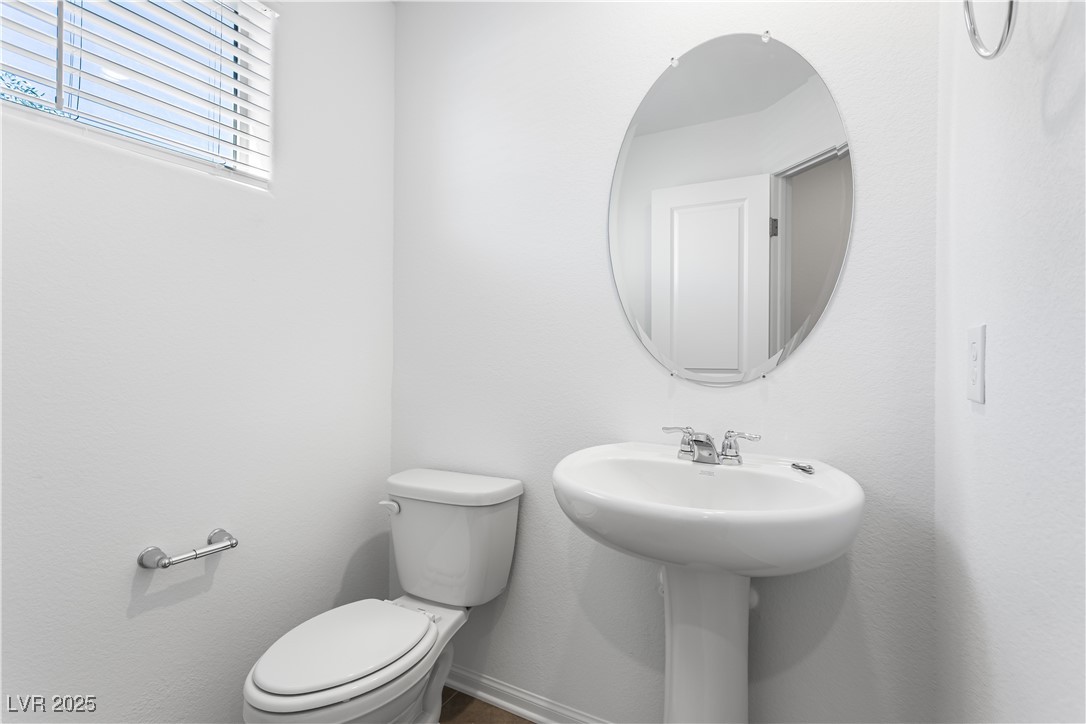 5646 Spring Trellis Street Las Vegas, NV 89113 - Photo 16 of 25 Half bath featuring toilet and baseboards