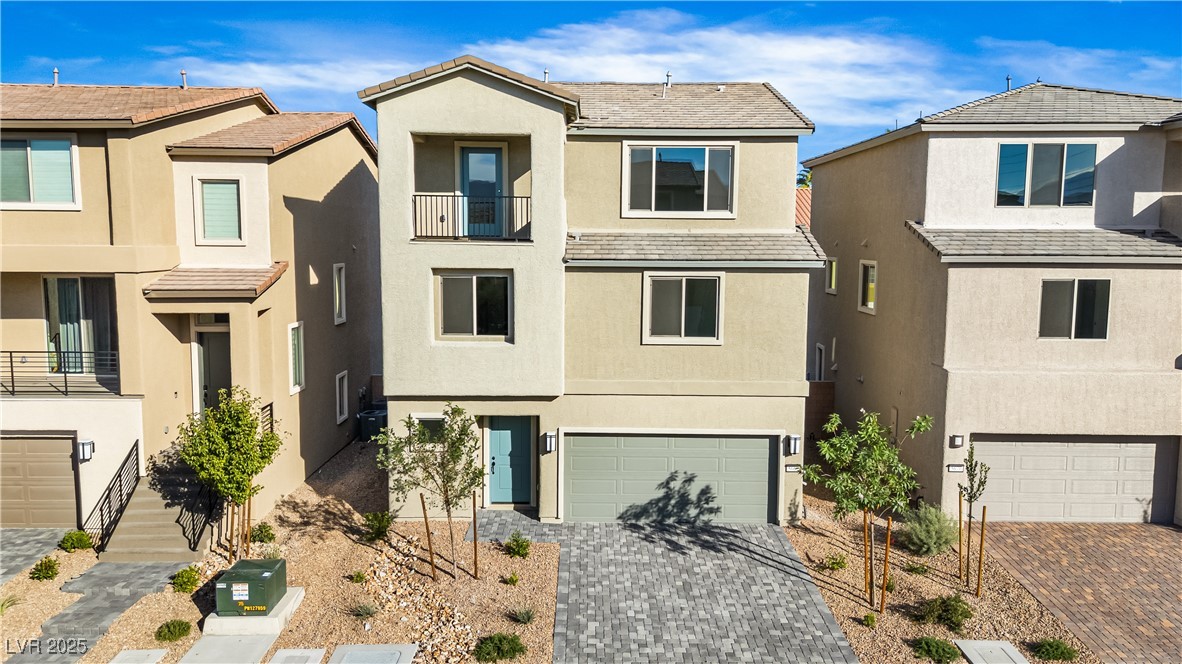 5646 Spring Trellis Street Las Vegas, NV 89113 - Photo 18 of 25 View of front of property featuring a balcony, an attached garage, stucco siding, decorative driveway, and a high end roof