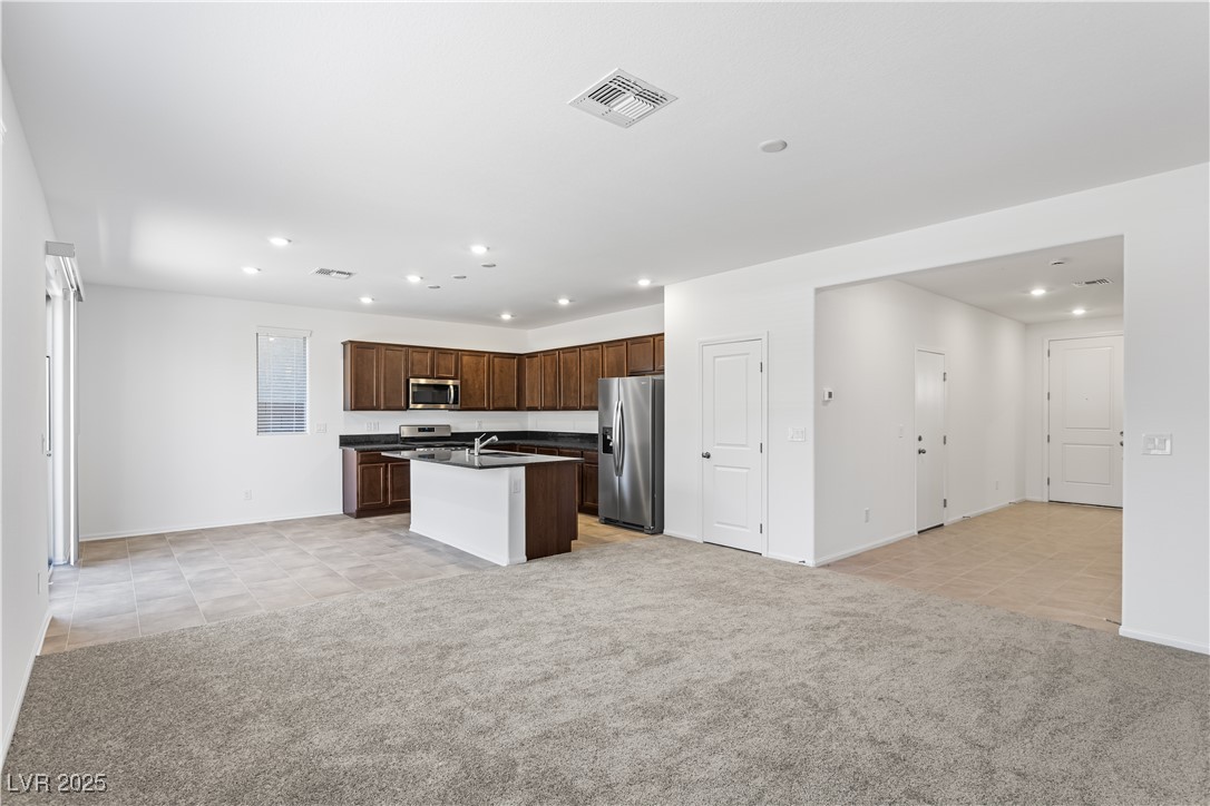 5646 Spring Trellis Street Las Vegas, NV 89113 - Photo 24 of 25 Kitchen with open floor plan, light colored carpet, light tile patterned floors, recessed lighting, and appliances with stainless steel finishes