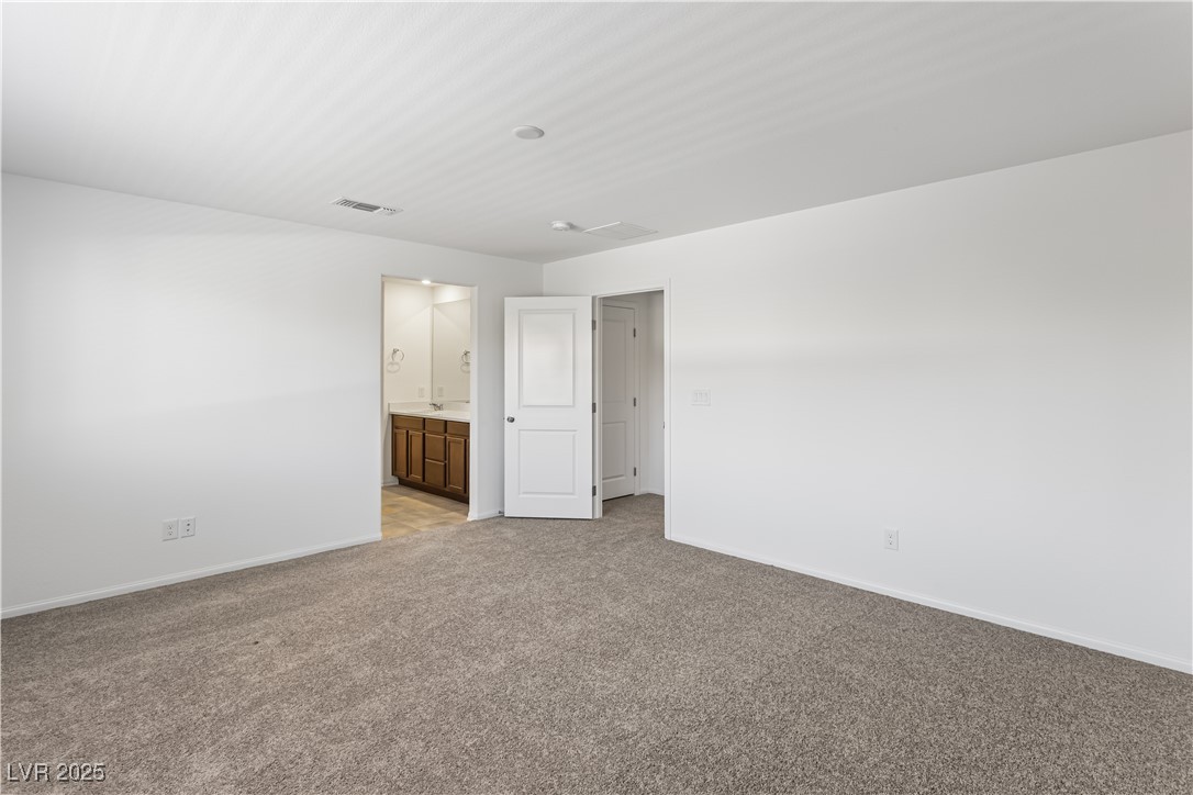 5646 Spring Trellis Street Las Vegas, NV 89113 - Photo 5 of 25 Empty room featuring baseboards and light carpet