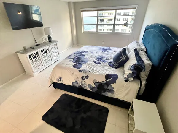 a large bed sitting in a bedroom next to a window
