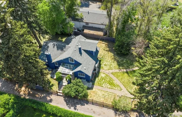 an aerial view of a house with a yard and trees all around