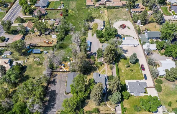 an aerial view of residential houses with outdoor space and trees