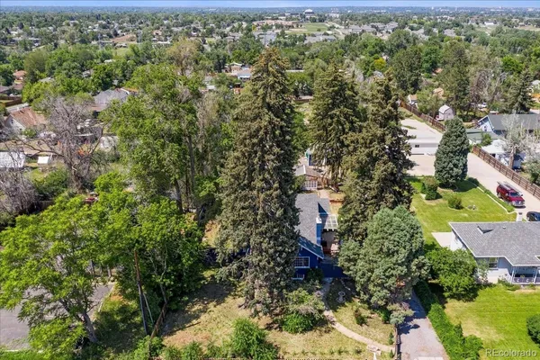 an aerial view of residential houses with outdoor space and trees