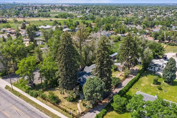 an aerial view of residential houses with outdoor space and trees