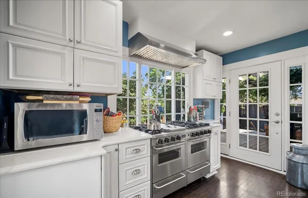 a kitchen with stainless steel appliances white cabinets and a stove top oven