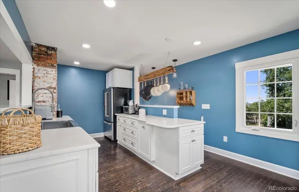 a kitchen with stainless steel appliances a sink and a stove with wooden floor