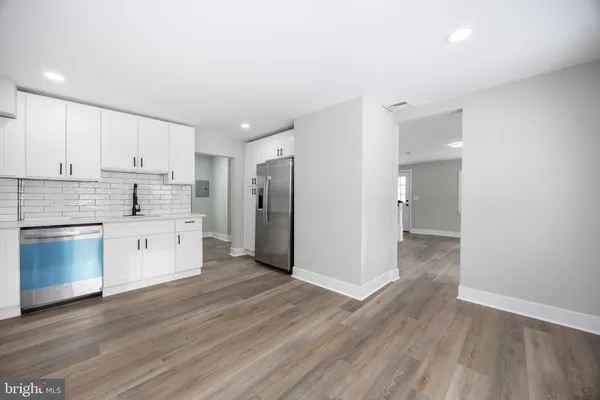 a kitchen with a refrigerator and white cabinets