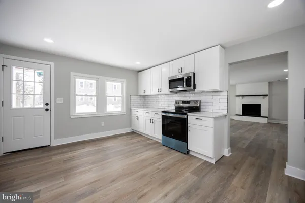 a kitchen with granite countertop a refrigerator stove top oven and sink