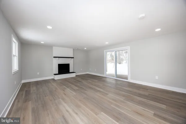 an empty room with wooden floor and fireplace