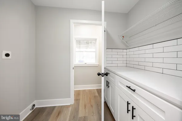 a view of a kitchen with wooden floor and cabinets