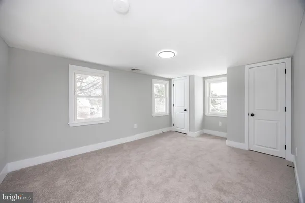 an empty room with windows and closet
