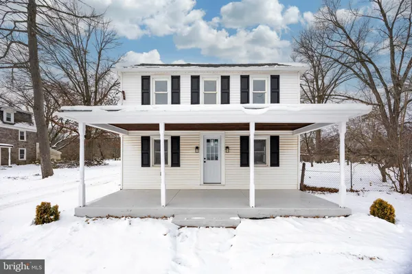 a view of a white house with a snow in the background