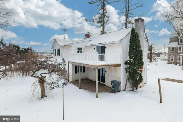 a front view of a house with a yard covered in snow