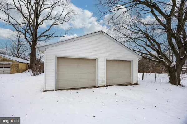 a view of white house with a snow in the yard