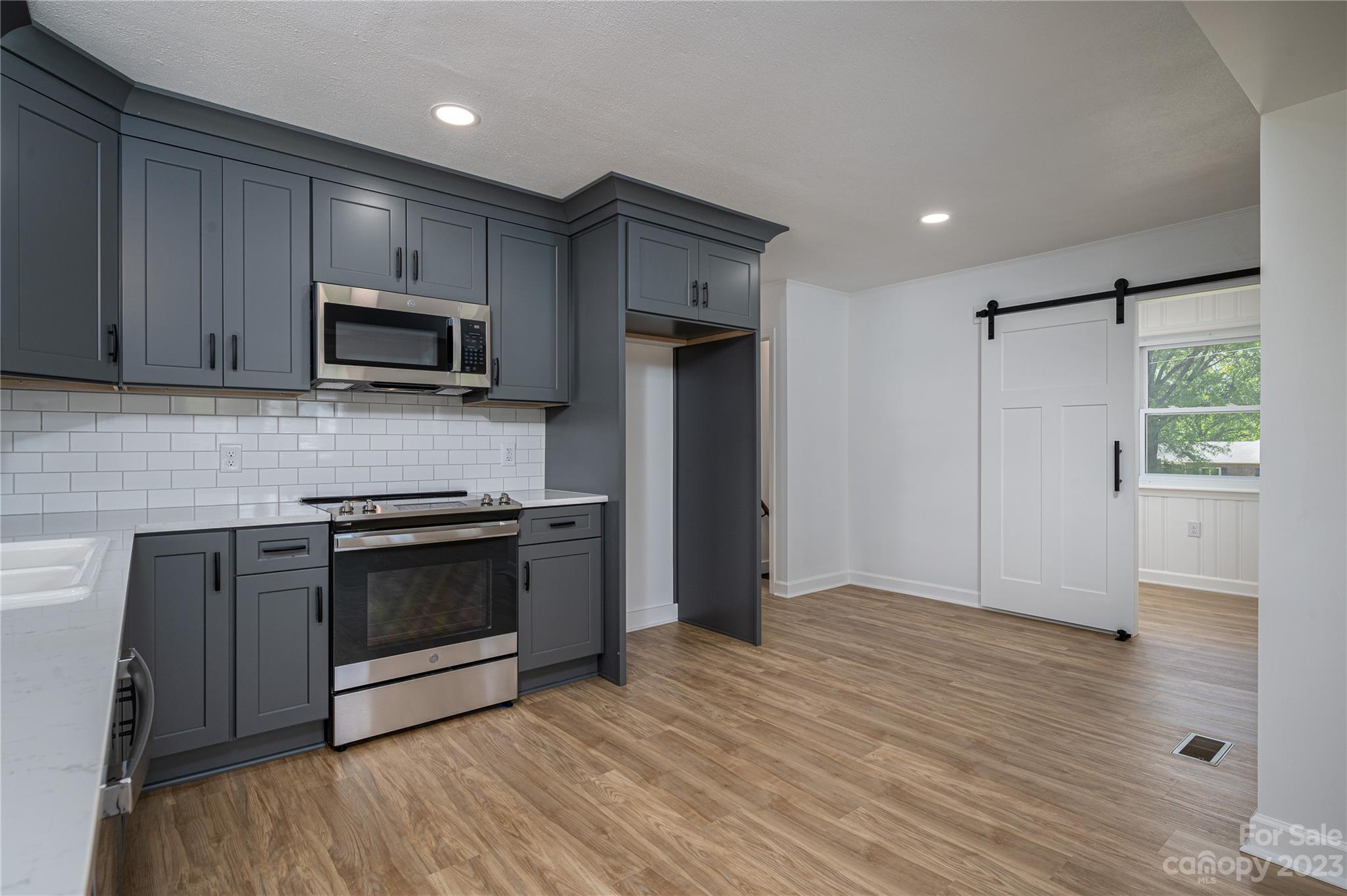 5722 Reepsville Road Vale, NC 28168 - Photo 11 of 30 a kitchen with kitchen island granite countertop stainless steel appliances and wooden cabinets