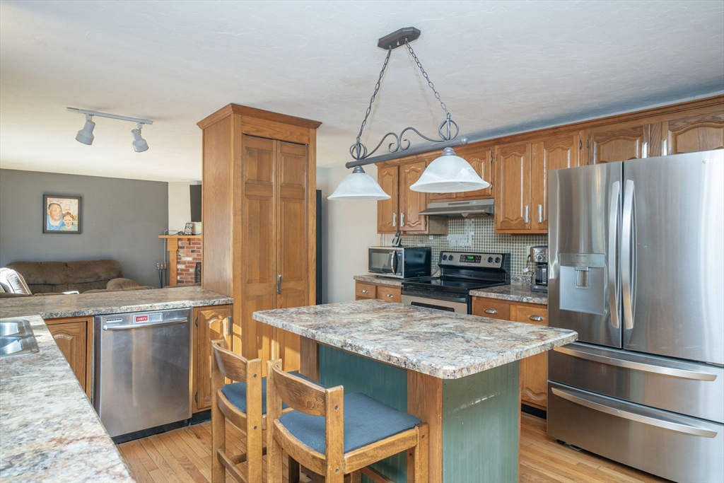 22 Dinahs Way Wareham, MA 02571 - Photo 11 of 42 a kitchen with stainless steel appliances granite countertop a stove refrigerator and dishwasher with wooden floor