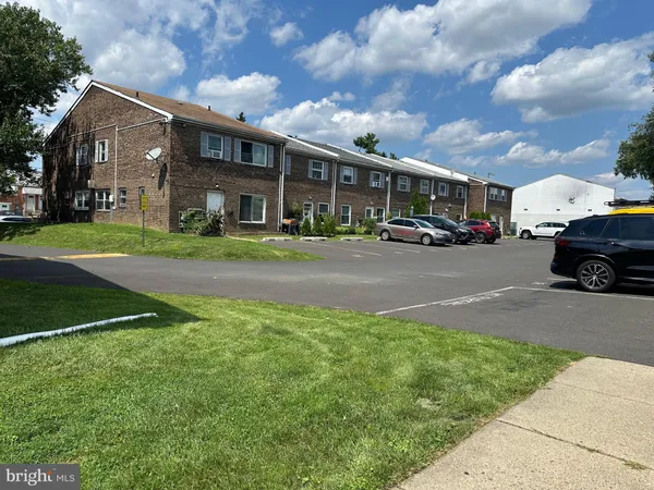 a view of a big house with a big yard and large trees