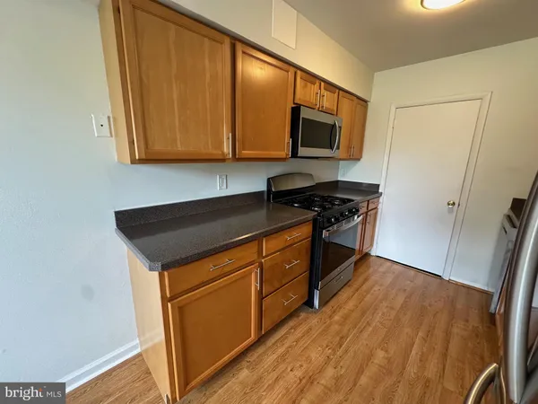 a kitchen with granite countertop a refrigerator stove and sink