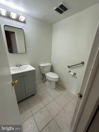 an empty room with wooden floor chandelier fan and windows