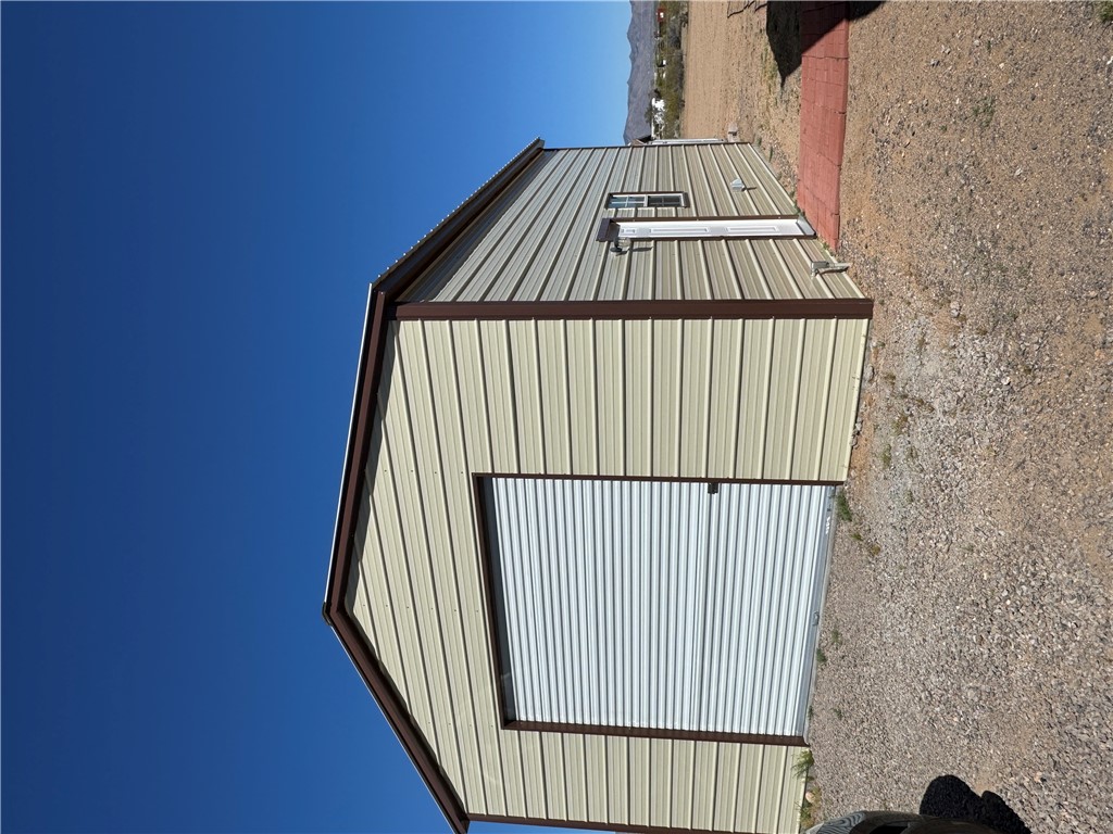4222 Estrella Road Golden Valley, AZ 86413 - Photo 2 of 34 Detached metal building featuring a roll-up door and an entry door with a window