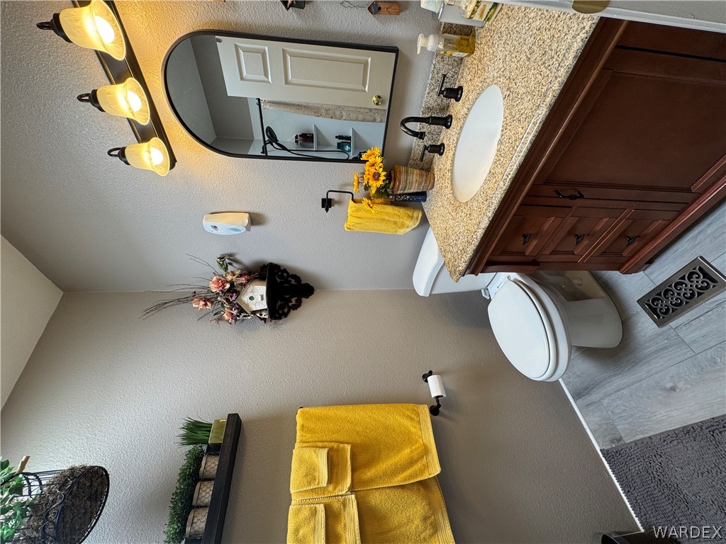 4222 Estrella Road Golden Valley, AZ 86413 - Photo 27 of 34 The bathroom features a vanity with a granite countertop, a white oval sink, and a dark wood cabinet