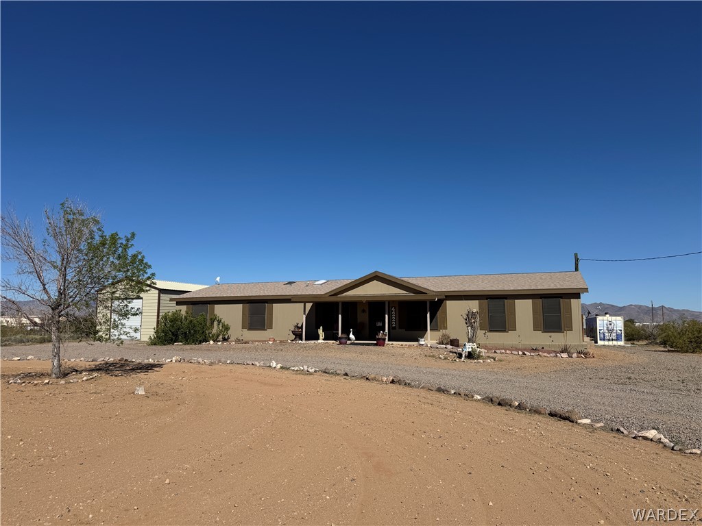 4222 Estrella Road Golden Valley, AZ 86413 - Photo 34 of 34 This property features a single-story residence with a covered front porch, set on a gravel driveway