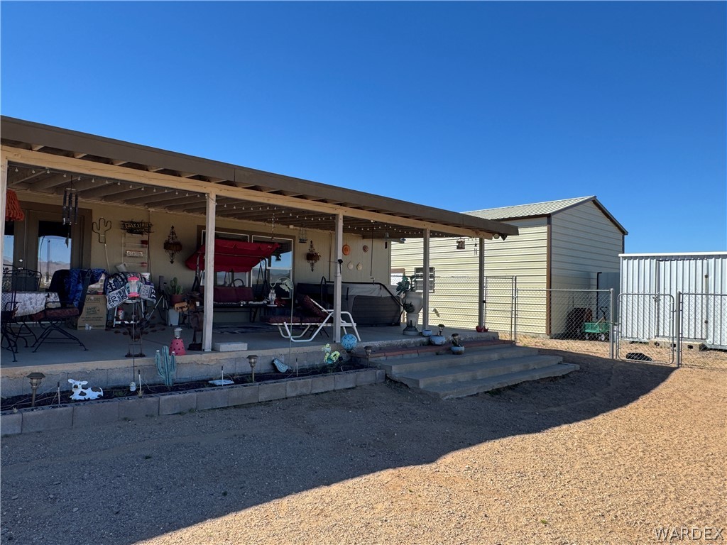 4222 Estrella Road Golden Valley, AZ 86413 - Photo 8 of 34 The property features an expansive covered patio, a separate storage building, and a fenced area