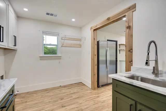 a view of a kitchen cabinets a sink and wooden floor