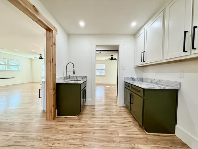 a kitchen with granite countertop a refrigerator and a stove top oven