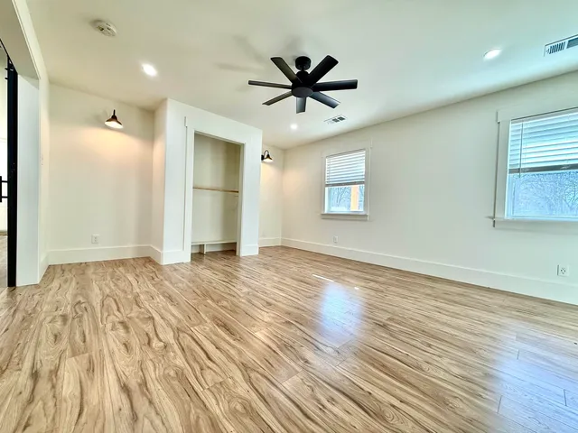 a view of an empty room and window with wooden floor